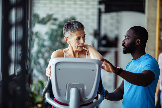 Senior woman exercising in a gym with her trainer