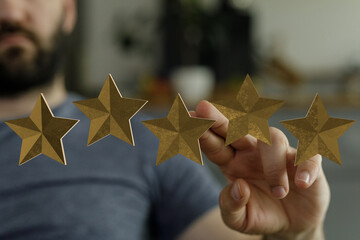 A person's hand reaching out to touch five golden stars representing a rating system and positive...