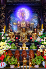 Vinh Trang buddhist Pagoda.   Main altar with Buddha and offerings.  My Tho Vietnam.