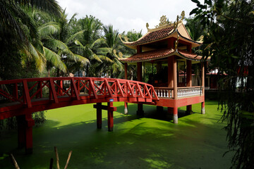 Truc Lam Phoung Nam Zen monastery. Red bridge leading to a small shrine. Can Tho. Vietnam.