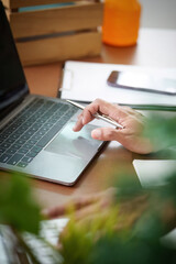 Remote Work. Professional using laptop and pen for productivity in a cozy workspace.