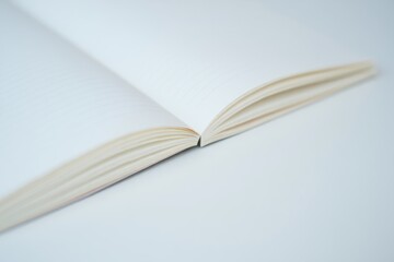 Open notebook on smooth white surface inviting personal writing and study