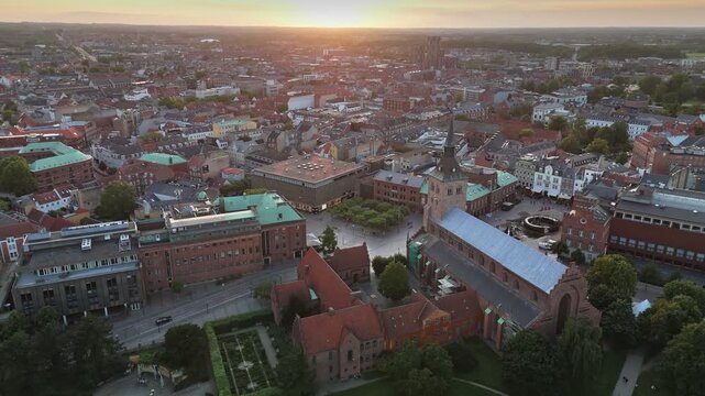 Breathtaking sunset over Odense, showcasing historic architecture and vibrant streets of Denmark's charming city. Aerial view of Odense, Denmark