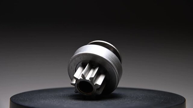 New parts are rotating. A Bendix starter gear drive for starting the engine on a gray gradient background. A classic gear drive transmits torque.