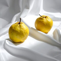Two yellow fruits on white fabric