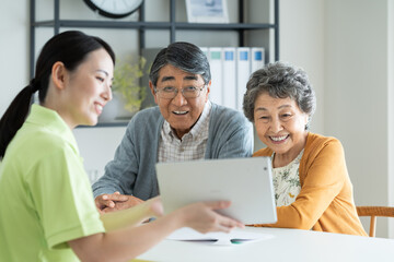 Obraz premium ケアマネジャーに相談するシニアの夫婦