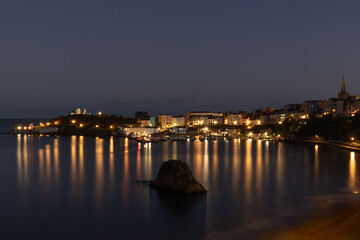 Tenby harbour, Pembrokeshire, Wales, at night with lights reflecting on the water