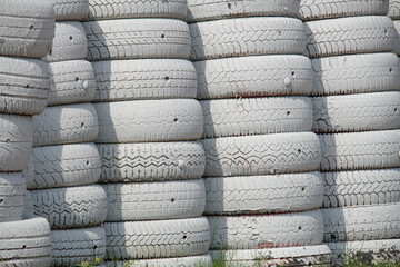 Stacked white painted tires forming a protective barrier and showcasing reuse