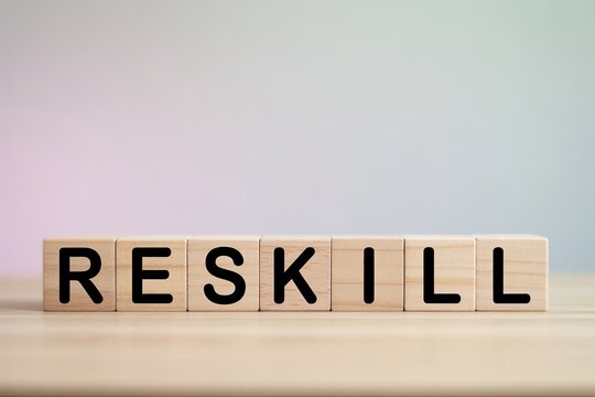 Wooden blocks spell out reskill word symbolizing learning and career development - Powered by Adobe