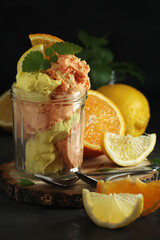 Lemon and orange ice cream scoops in glass jar