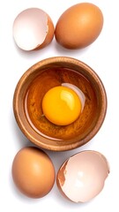 Three brown eggs, one cracked, in a small wooden bowl with a yolk