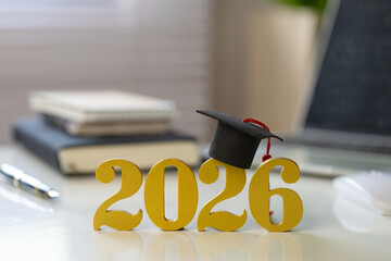 2026 graduation concept with golden numbers and a mortarboard on a clean desk, symbolizing scholarships, academic success, and future goals, perfect for banners, promos, and education marketing.