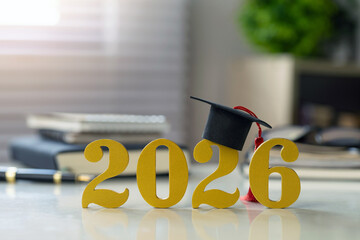 Class of 2026 graduation concept with golden numbers and mortarboard on desk, symbolizing scholarship, academic success, admission, and future goals; ideal for education promos and celebratory design.