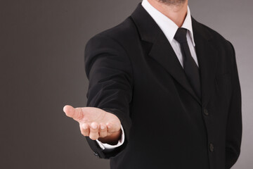 Asian Man standing and shows outstretched hand. COPY SPACE. No face.