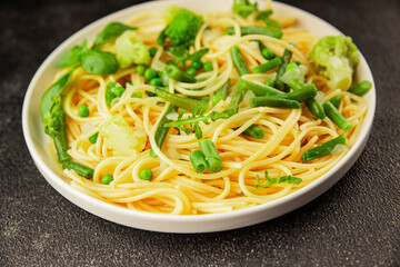 Spaghetti vegetables green peas, broccoli, string beans, kohlrabi vegetarian pasta tasty snack fresh delicious gourmet food background on the table rustic top view copy space vegan food
