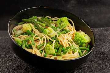 Spaghetti vegetables green peas, broccoli, string beans, kohlrabi vegetarian pasta tasty snack fresh delicious gourmet food background on the table rustic top view copy space vegan food