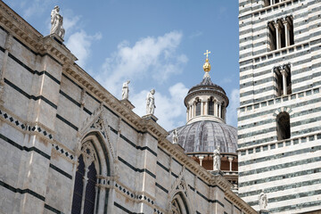 Obraz premium Marble statues on front of the 14th century Duomo di Siena, Italy. UNESCO World Heritage Site.