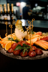 Fruit platter with sliced pear, orange, apple and grapes