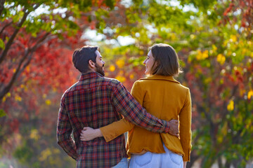 Happy caucasian couple walking together in the public park during autumn with maple and beech tree for fall color travel destination and family happiness