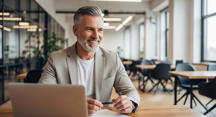 Fototapeta premium Professional male employee or businessman using laptop and mobile phone in modern office. Copy space.