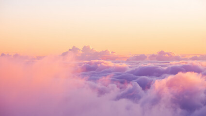 Dreamy pastel sunset sky filled with soft fluffy clouds in shades of pink purple and orange creating a serene and ethereal atmosphere above the horizon