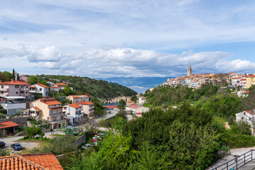 KRK Island, Vrbnik, Croatia - April 19, 2025: Cityscape. View of the coastline, rocky beach, and mountains