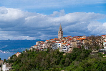 KRK Island, Vrbnik, Croatia - April 19, 2025: Cityscape. View of the coastline, rocky beach, and mountains