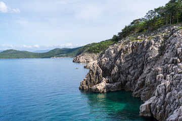 KRK Island, Vrbnik, Croatia - April 19, 2025: Cityscape. View of the coastline, rocky beach, and mountains