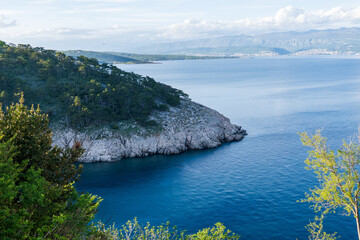 KRK Island, Vrbnik, Croatia - April 19, 2025: Cityscape. View of the coastline, rocky beach, and mountains
