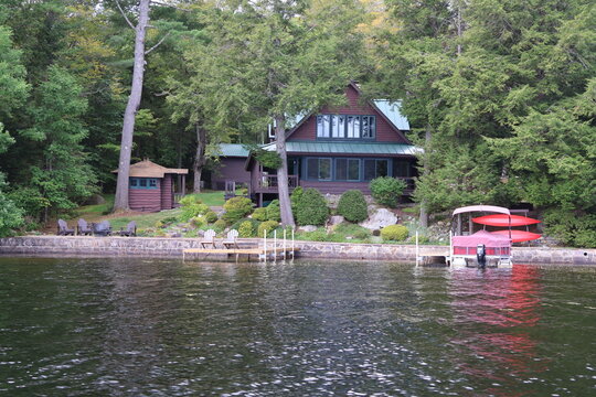 A cozy lakefront house with a dock and watercraft