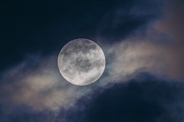The moon as seen behind a cloud in the middle of the night