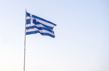 Greece sign symbol. Greek national flag on flagpole waving in the sky