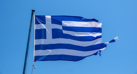 Obraz premium Greece sign symbol. Greek national flag on flagpole waving in the wind, blue sky
