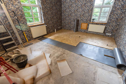 Ein Wohnzimmer im Aufbau. Verlegen von Holzplatten.