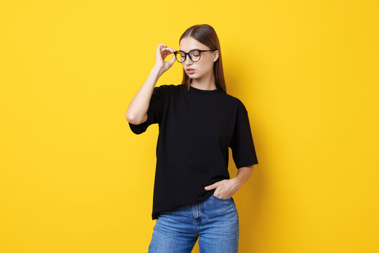 Woman wearing stylish black t-shirt on yellow background