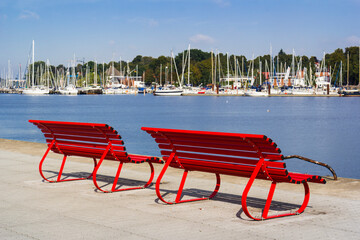 Red street bench in front of the Baltic sea, Röstock, Germany