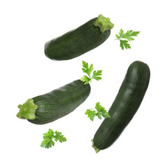 Fresh zucchini and parsley falling against white background