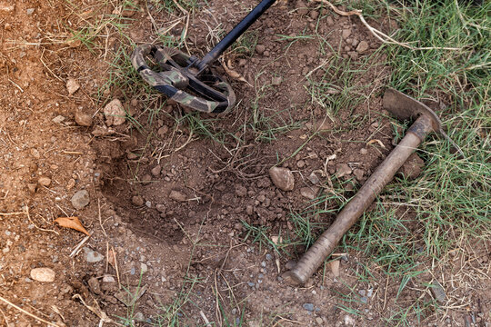 A metal detector and a small excavation pick, photographed close-up.