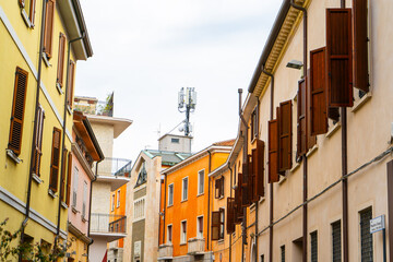 Italy, Rimini town windows shutters. Old narrow Italian street in Rimini center city. Building architecture houses.