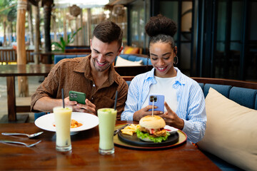 A diverse couple captures food before eating, dining culture lifestyle sharing and social rituals