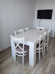Modern white dining table set with chairs in minimalist living room or kitchen 