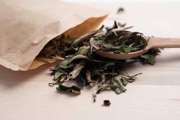 Green tea leaves on a wooden board with a spoon. Tea ceremony. Herbal treatment.