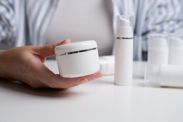 Jar of spa cream in the hands of a girl. Skin care. Medical and dermatological cosmetics for hands. Beauty and health of a woman. Spa treatments for the body. Container with natural cream close-up