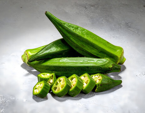 Pile of fresh green okra pods and cut slices