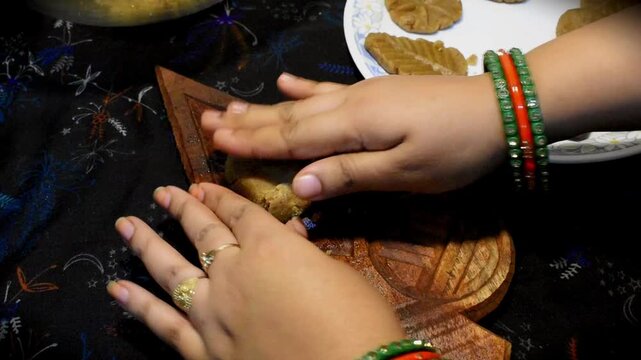 Indian woman preparing Thekua, the traditional sweet made during Chhath Puja, in a home kitchen. Showing Indian traditions, festive food preparation, and cultural heritage.