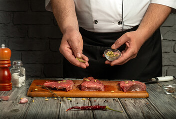 In a rustic kitchen, a chef is seen seasoning beef steaks with a mix of spices and herbs. The atmosphere is cozy with wooden details and fresh ingredients on the table