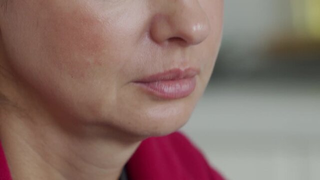 lower part of a woman's face as she experiences a hiccup, showing the subtle muscle movement and brief facial expression.