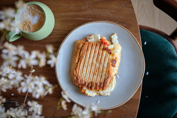 Toast, coffee and blossoming cherry branches on a wooden background