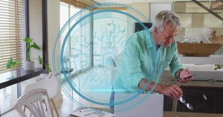 Senior man reaching for smartphone then typing laptop keys generating cyber security overlay - Powered by Adobe