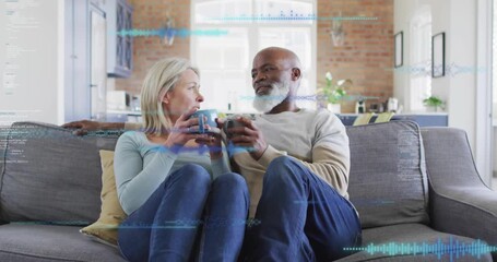 Mature woman and man lowering mugs spawning waveforms and code overlay visualizing technology data - Powered by Adobe